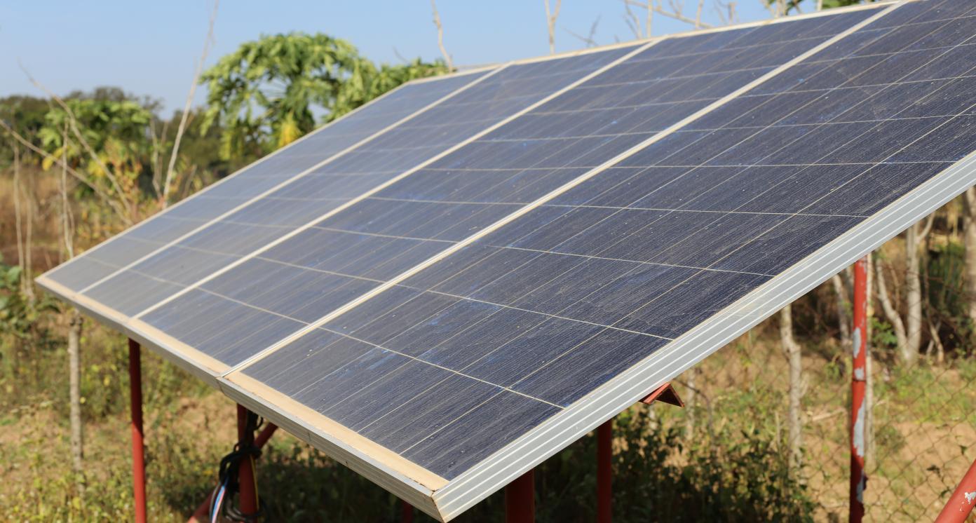 Close up outdoor view of solar panels located in a rural garden in Benin in order to supply energy for a pumping system. African agricultural picture of a traditional technology.