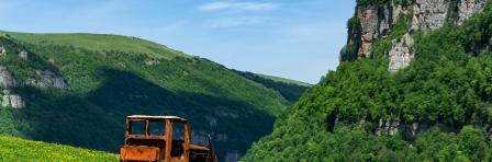 An out of order agricultural tractor with some tree covered rocks in Tavush region of Armenia