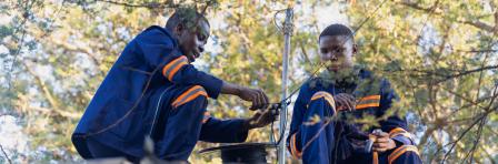 fiber optic cable install, african workers on the roof, roll of cable to install residential internet